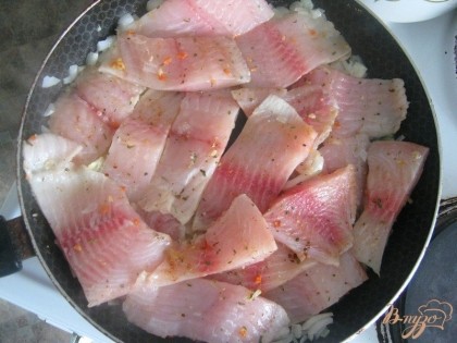 На сковороду с обжаренным репчатым луком положить куски рыбы, слегка обжарить с обеих сторон.