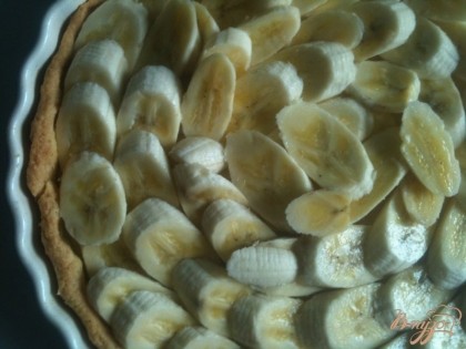 Готовый тарт охладить и на поверхность выложить кусочки бананов.