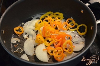 На сковороде разогретой с растит.маслом обжарить лук, затем добавить перец и тушить слегка помешивая.