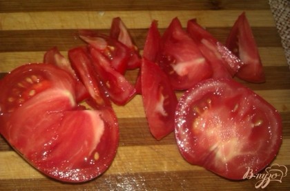 Зрелые (лучше салатных сортов) томаты также промываем, избавляем овощи от плодоножек. Вырезаем у помидоров места прикрепления плодоножки, а затем режем дольками.