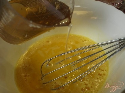 Тонкой струйкой «в нить», очень медленно вливать остывший сироп во взбитые яйца, постоянно перемешивая, чтобы получить однородную смесь.