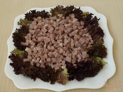 Блюдо застелить листьями салата и выложить нарезанную кубиками варено-копчёную шею.