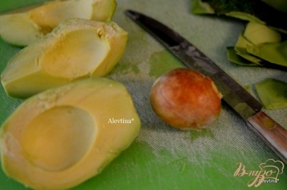 Авокадо очистить от кожицы и семени и порезать на пополам. Одну половинку порежем тонко на салат, вторую отложим на заправку.