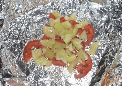 Теперь берем прямоугольный кусок фольги, смажем слегка ее подсолнечным маслом и выкладываем слоями, сначала часть помидор, сверху часть перца,