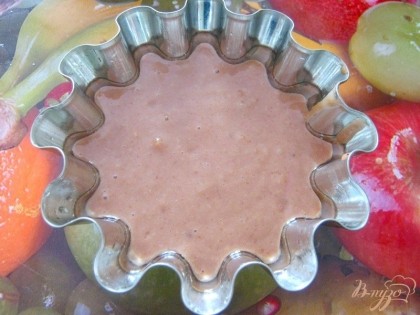 В форму для кексов, предварительно смазаанную маслом, влить часть теста (примерно 1/4).