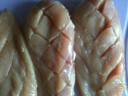 Мясо куриных грудок обсушить бумажным полотенцем и при помощи ножа сделать надрезы.