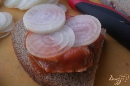 Сверху выкладываем на бутерброды кольца свежего лука – буквально по 2-3 штуки будет достаточно.