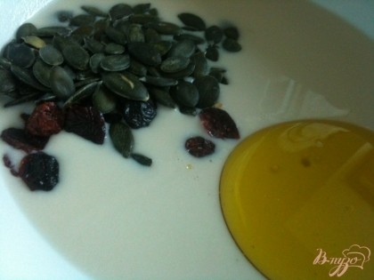 Затем оливковое масло , семечки и сушеную клюкву.