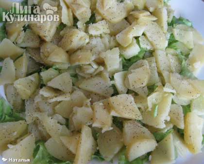 На блюдо нарезать крупно салат, или порвать на мелкие листики, сверху салата положить крупно, но тонко нарезанный картофель.  Поперчить.