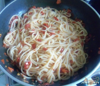 Готовые спагетти смешать с томатным соусом.