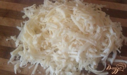 Любой сыр полутвердых сортов (главное, чтобы он хорошо плавился) измельчаем на крупной терке.