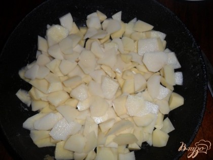 В глубокую сковороду или другую жаростойкую емкость наливаем растительное масло, крошим половину картофеля небольшими кусочками.