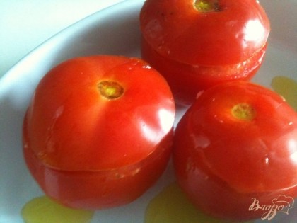 В форму для запекания налить немного оливкового масла и установить фаршированные томаты, закрыть верхушками.