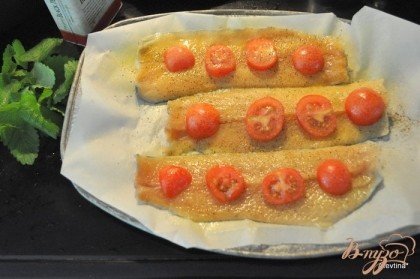 Посолить и поперчить,выложить поверх филе разрезанные помидоры и сбрызнуть олив.маслом.