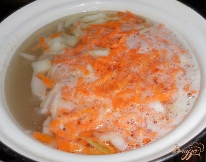 Когда бульон закипит, выкладываем в него картофель, морковь и лук, добавляем соль, перемешиваем. Доводим все вместе до кипения.