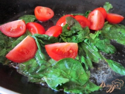 Сковороду разогреть с оливковым маслом и кусочком сливочного.Уложить листья шпината (если они крупные, то можно немного порвать руками) и кусочки томатов.Обжарить 1 минуту.