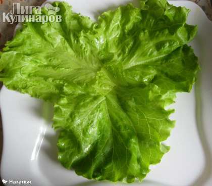 На плоское блюдо выложить листья салата.