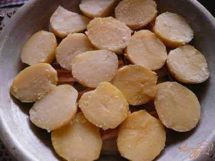 Затем картофелины разрезаем пополам и выкладываем их в форму в один слой.