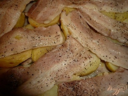 На картофель выкладываем оставшийся бекон (желательно чтобы вся картошка была покрыта мясом). Посыпаем немного солью и черным молотым перцем. Отправляем блюдо в разогретую духовку на 10-15 минут, чтобы бекон наполовину приготовился.