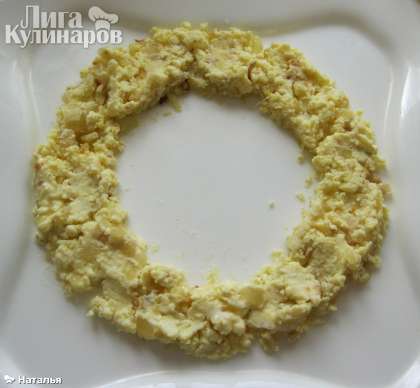 На плоское блюдо выкладываем в форме кольца желток с луком.