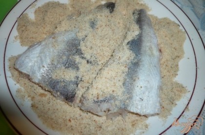 Панировочные сухари высыпаем в плоскую тарелку. Филе разрезаем на порционные куски и обваливаем в панировочных сухарях.