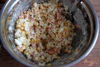Мелко нарезать отваренные яйца, крабовые палочки, добавить сцеженную кукурузу, добавить немного майонеза