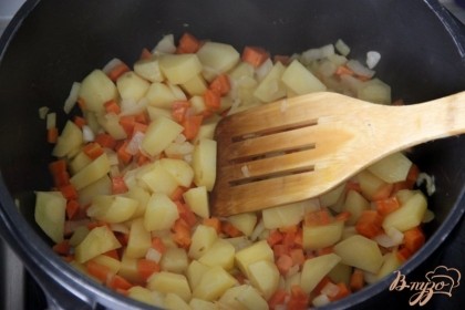 Отдельно, в кастрюле с толстым дном, обжарить подготовленные картофель, лук и морковь