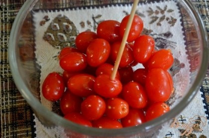 Проткнуть каждую помидорку зубочисткой или деревянным шампурем с 2х разных сторон.