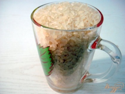 О рисе. Для этого блюда прекрасно подходит пропаренный рис, который после приготовления не слипается. Чтобы правильно сварить рис, нам понадобится мерка для риса и для воды одна и та-же. В данном случае меркой послужит стакан. Отмеряем стакан риса и два стакана воды. Рис перебираем.