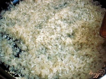 Рис высыпаем на сковороду с 50 граммами масла и помешивая слегка обжариваем, пока рис не станет прозрачным. Пересыпаем в кастрюлю с толстым дном с скручиваем газ до минимума, таймер наставляем на двадцать минут.