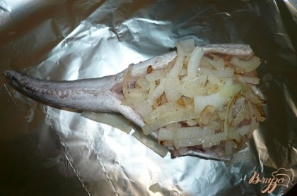 Обжариваем нарезаный лук на сковороде с небольшим количеством растительного маслаи выкладываем обжаренный лук на внутреннюю часть рыбьей тушки.