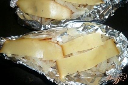 Сверху на лук кладем немного сыра (нарезанного тонко или натертого на терке), укладываем рыбку на сковороду для духовки, на дно сковороды наливаем немного воды.