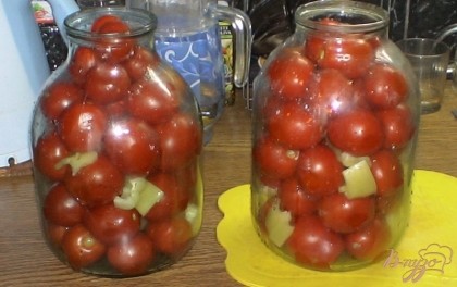 В сухие банки укладываем помидоры, которые предварительно накалываем вилкой. А также кладем перец.