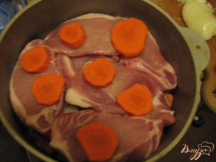 В чугунок укладываем слоями антрекот и морковь, не забывая присаливать каждый кусок мяса.