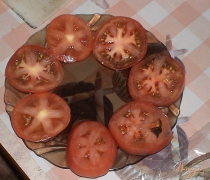 Режем тонкими колечками помидор и выкладываем его на тарелку кругом. Немного присаливаем и перчим помидорчики.