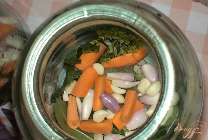 Сверху кладем чеснок, морковь и лук, поровну в две банки.