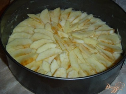 На тесто выкладываем яблоки и слегка посыпаем сахаром,а сверху выкладываем оставшееся тесто и разравниваем его.