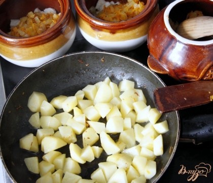Картофель очистить, нарезать небольшим кубиком, обжарить на сковороде. Добавить по горшочкам.
