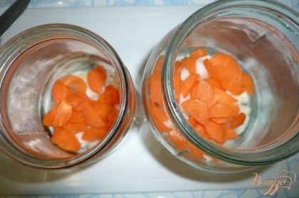 Лук некрупно нарезаем и примерно третью часть откладываем. Морковь нарезаем небольшими тонкими дольками. На дно банок выкладываем большую часть нарезанного лука, на него морковь. Овощи распределяем по банкам примерно равномерно.