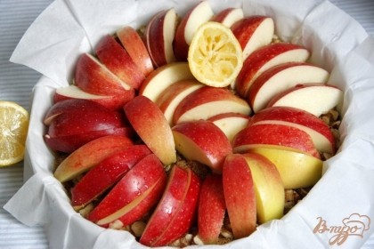 Яблоки очистить от семенной коробочки, нарезать дольками, сбрызнуть лимонным соком, выложить на орехи.