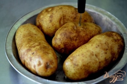 Поставить в горячую духовку 180 гр на час картофель, предварительно проткнуть вилкой каждую картофелину.