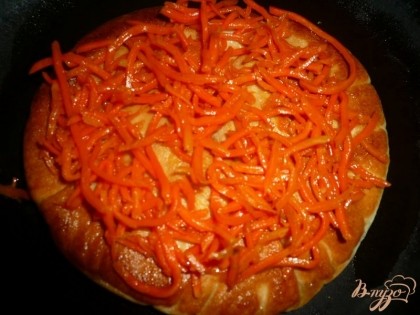 Выкладываем на румяную сторону питы морковь по-корейски и распределяем её по всей поверхности. На морковь выкладываем натертый сыр.