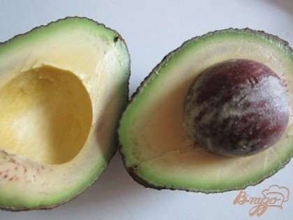 Плоды авокадо разрезать на две части и вынуть косточки.