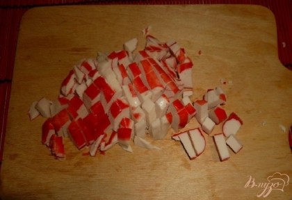 Крабовое мясо (предварительно размороженное) нарезаем кубиками.