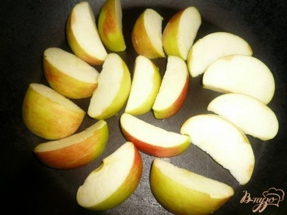 Выкладываем нарезанные яблоки на дно сковородки, подходящей для духовки. Яблоки и курица дадут достаточно сока и жира, поэтому смазывать сковороду маслом не обязательно.