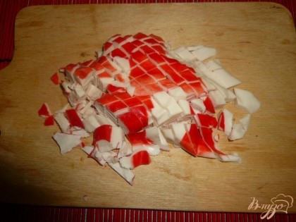Крабовое мясо (или палочки), предварительно разморозив, нарезаем кубиками.