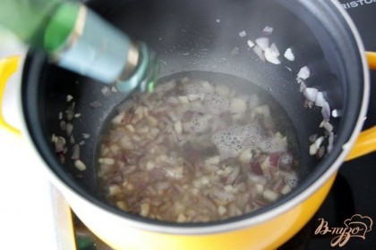 Лук и чеснок мелко нарезать, обжарить на оливковом масле до прозрачности, добавить вино, сушеные травы, варить 3 мин.