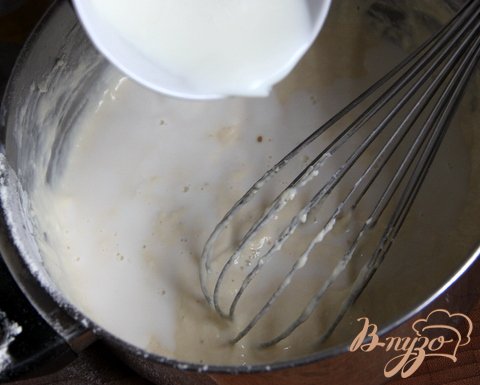 Молоко довести до кипения и ввести в блинную массу, постоянно помешивая. Если тесто очень жидкое, добавить ещё немного муки.