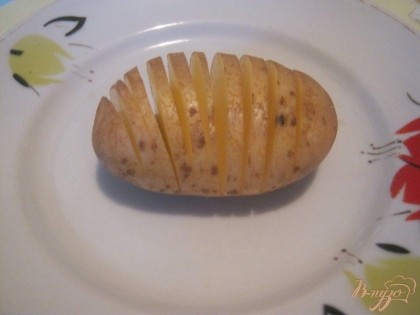 Картофель нарезать поперек тонкими ломтиками, не дорезая до конца по 5 мм.