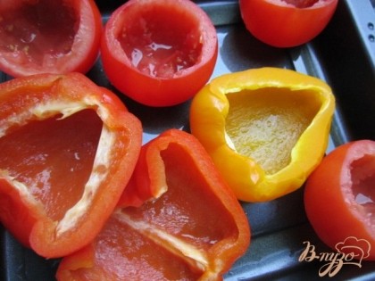 На небольшой протвень смазанный оливковым маслом поставить пустые томаты и половинки перцев.